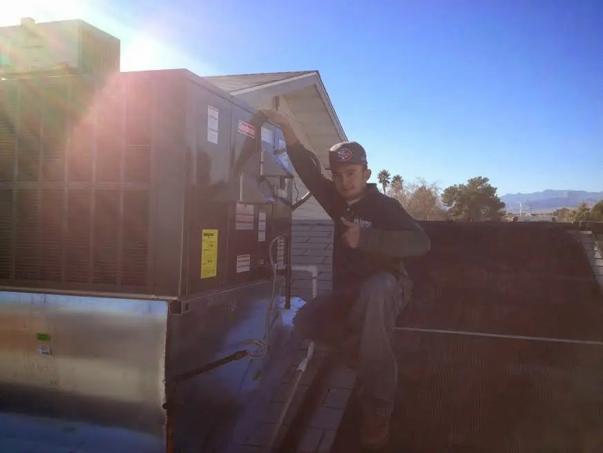 HVAC technician performing HVAC Inspection on a rooftop unit in Joliet